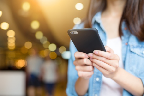 スマートフォンを見てる女性の画像